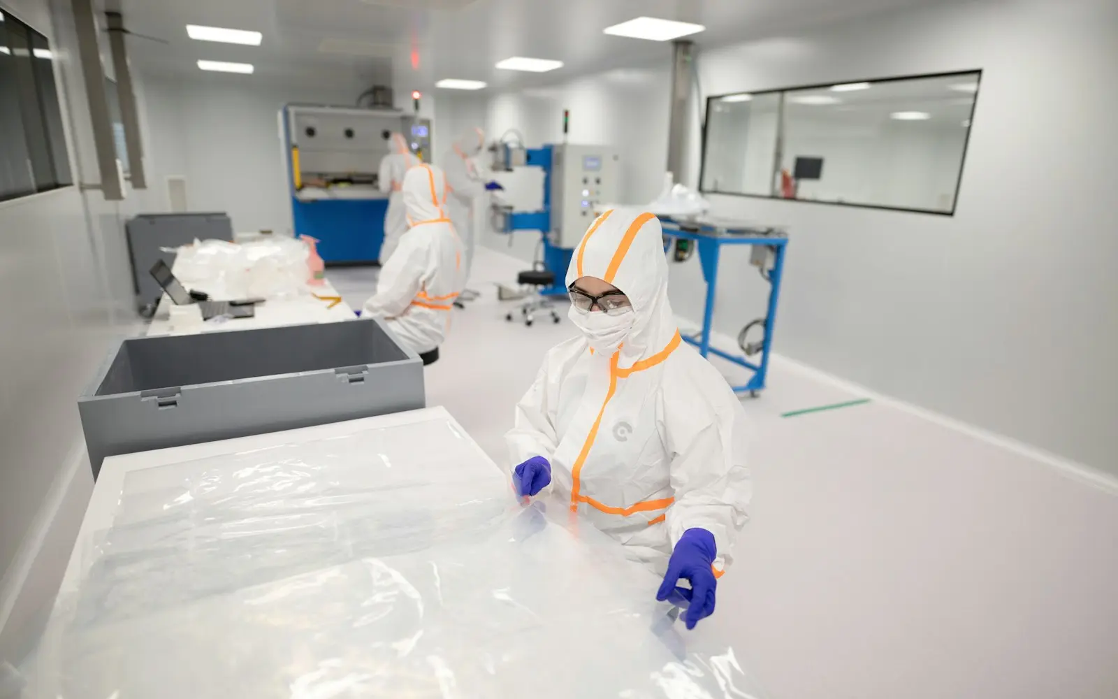 Technicians in cleanroom suits at work in a pharmaceutical unit