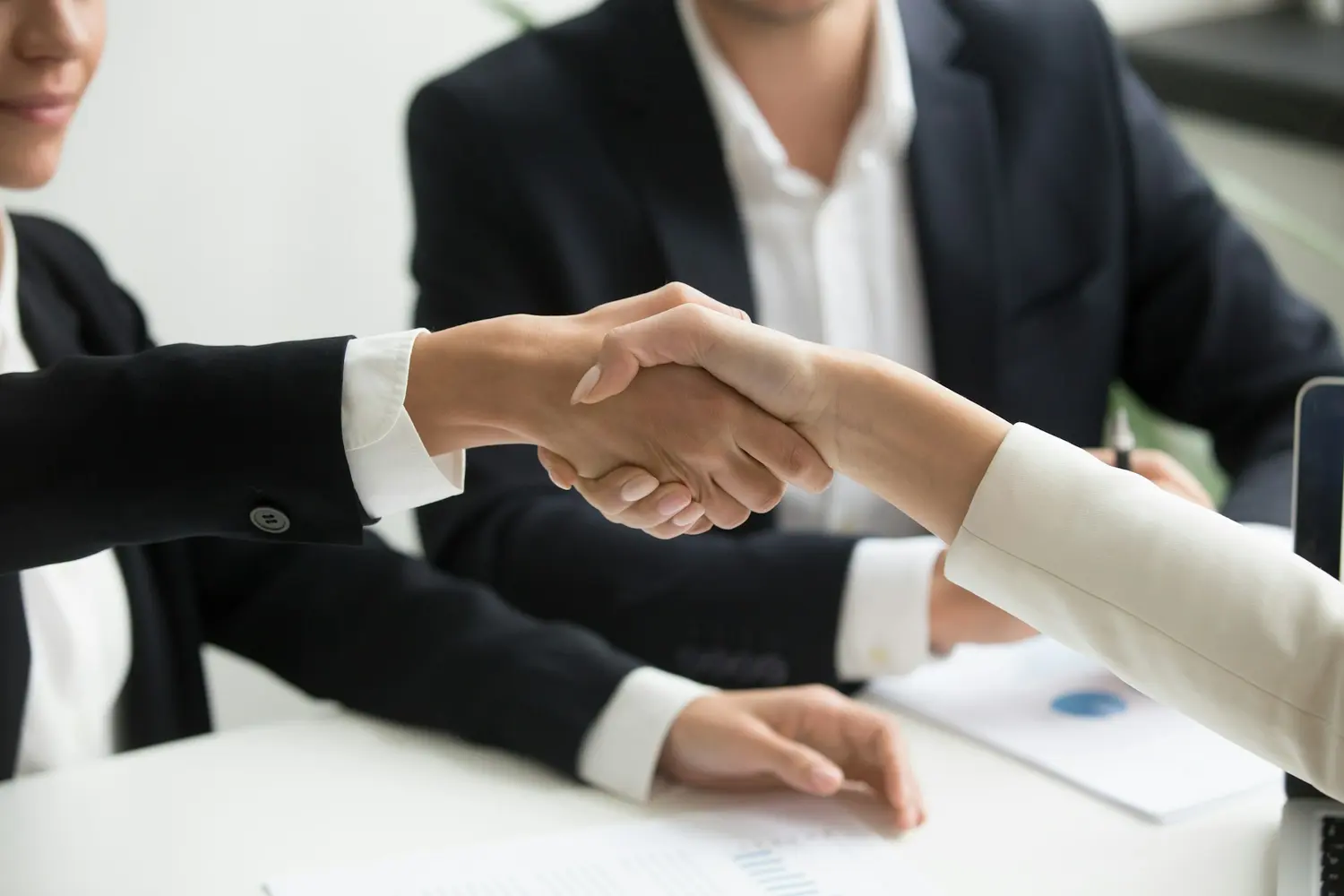 A handshake across a meeting table